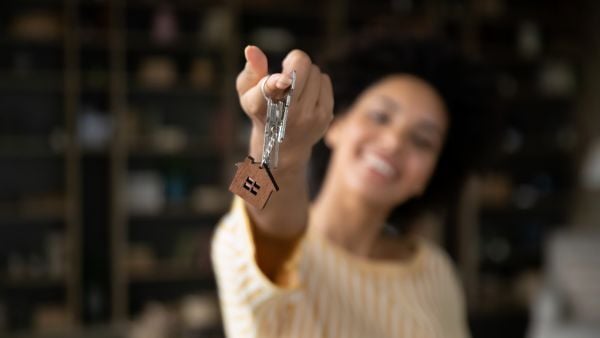 Out of focus image of a woman holding keys to a new home