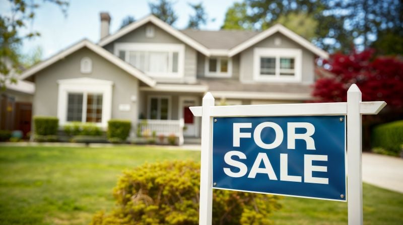 Image of a Northern Ohio home with a For Sale sign in the foreground